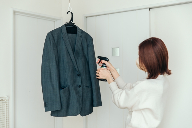 スーツの手入れをする女性